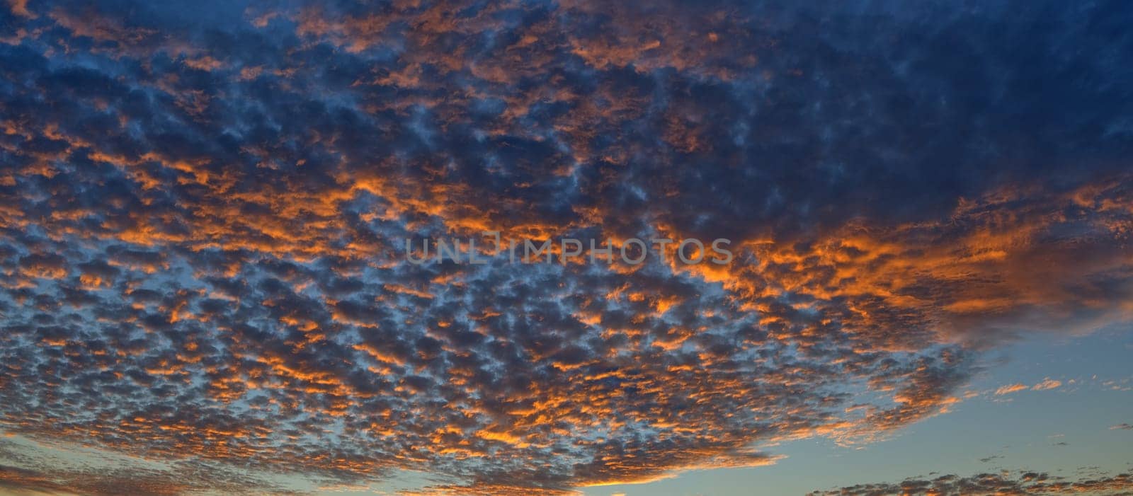 Scenic panoramic view of colorful sunset and cloudscape, dramatic panorama evening sky after sunset