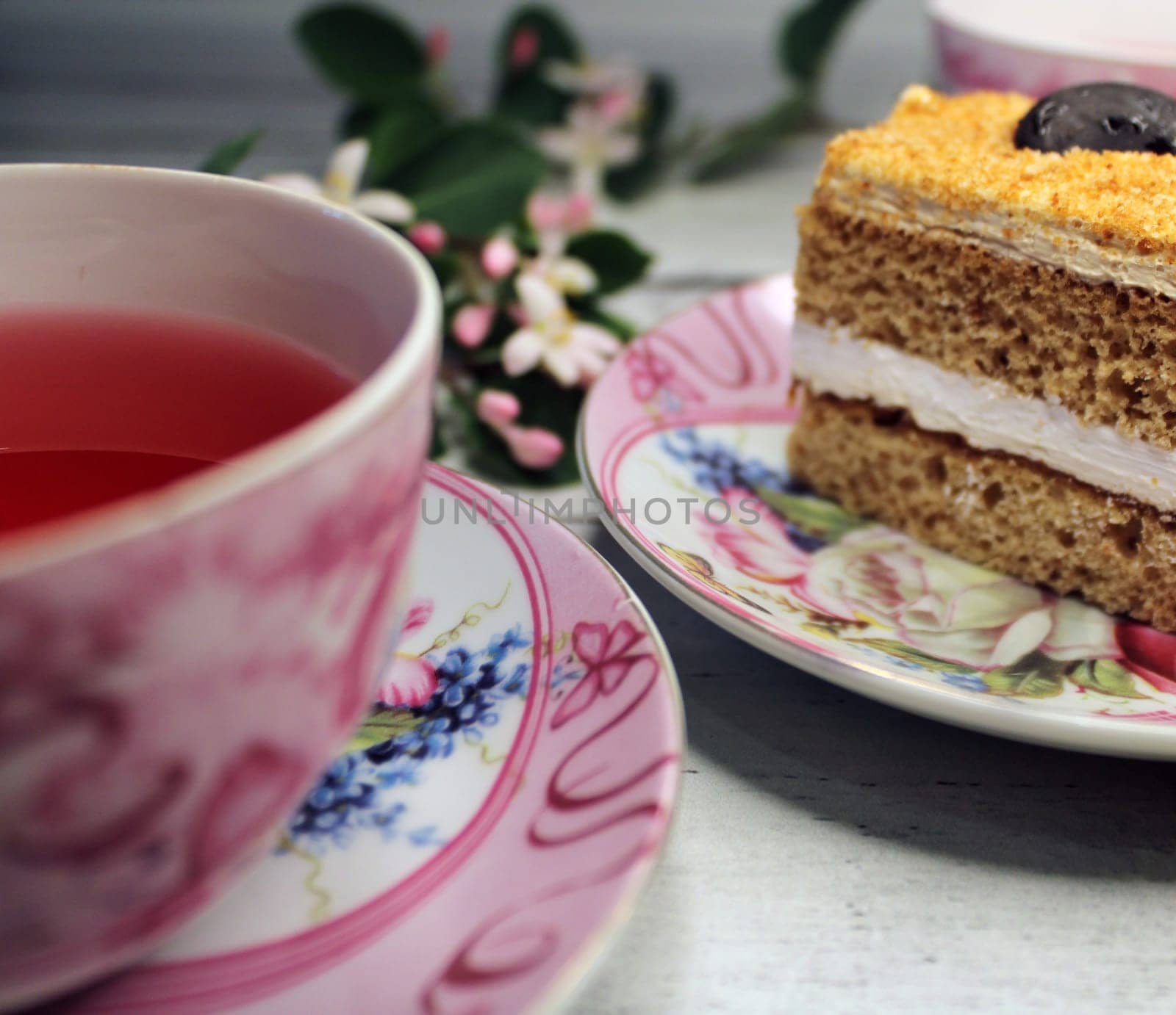 A cup of tea and a close-up cake on a wooden table..