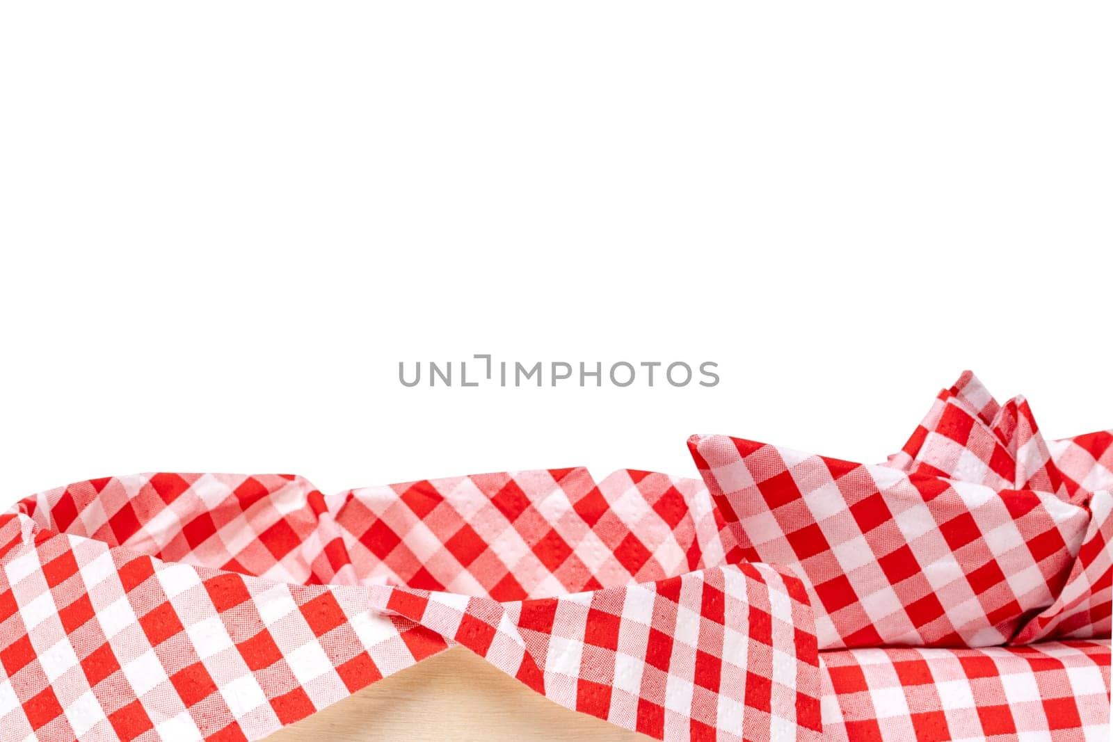 Closeup of a empty straw basket with a red checkered napkin and a folded ship isolated on a white background. For your food and product display montage. Macro.