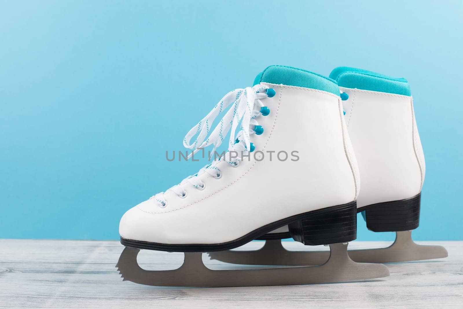 Pair of ice skaters in front of a blue background, winter sport equipment