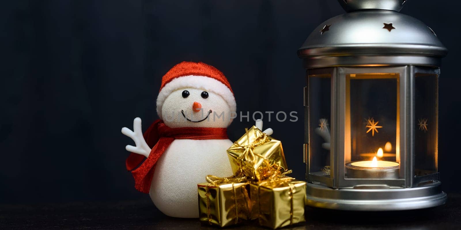 Christmas composition: snowman, lantern with candles, bright shiny boxes with gifts, dark blue background, place for logo, lettering, layout, mockup.