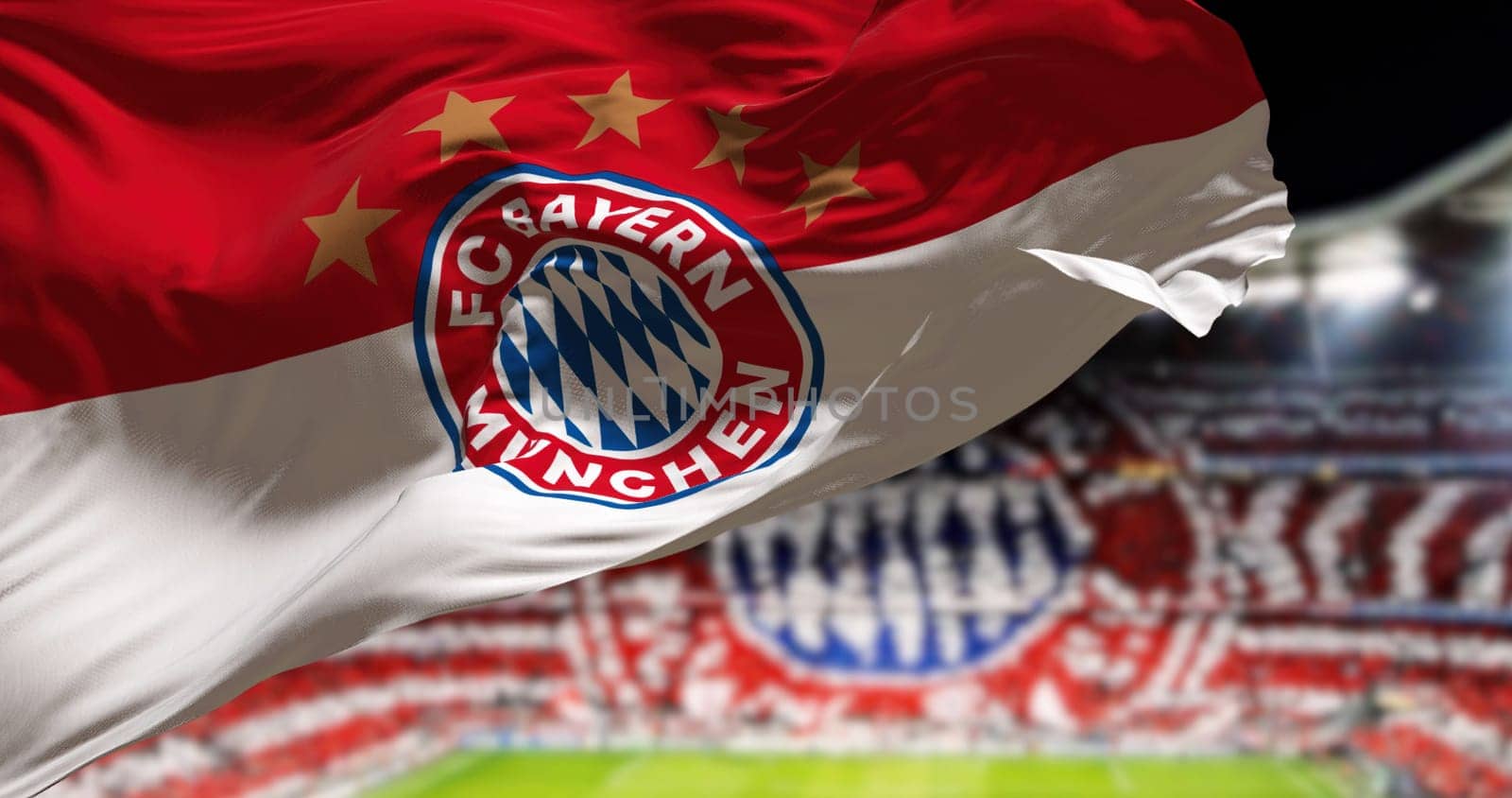 Munich, GER, May 2022: The Bayern Munich Flag waving in the wind with Allianza Arena Stadium blurred in the background. Bayern Munich is a German sports club based in Munich. Seamless loop in slow motion