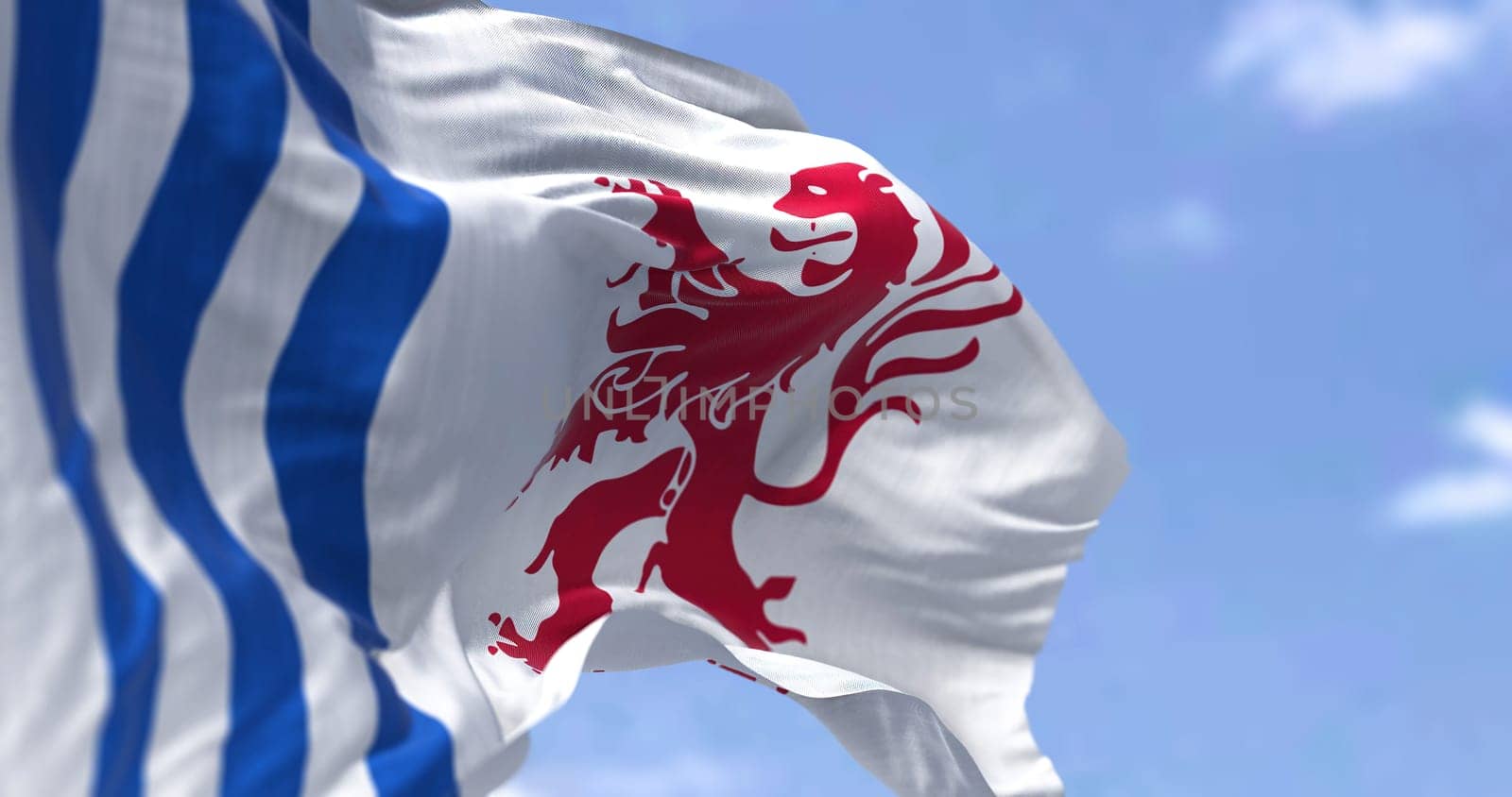 The flag of Nouvelle-Aquitaine waving in the wind on a clear day. Nouvelle-Aquitaine is the largest administrative region in France