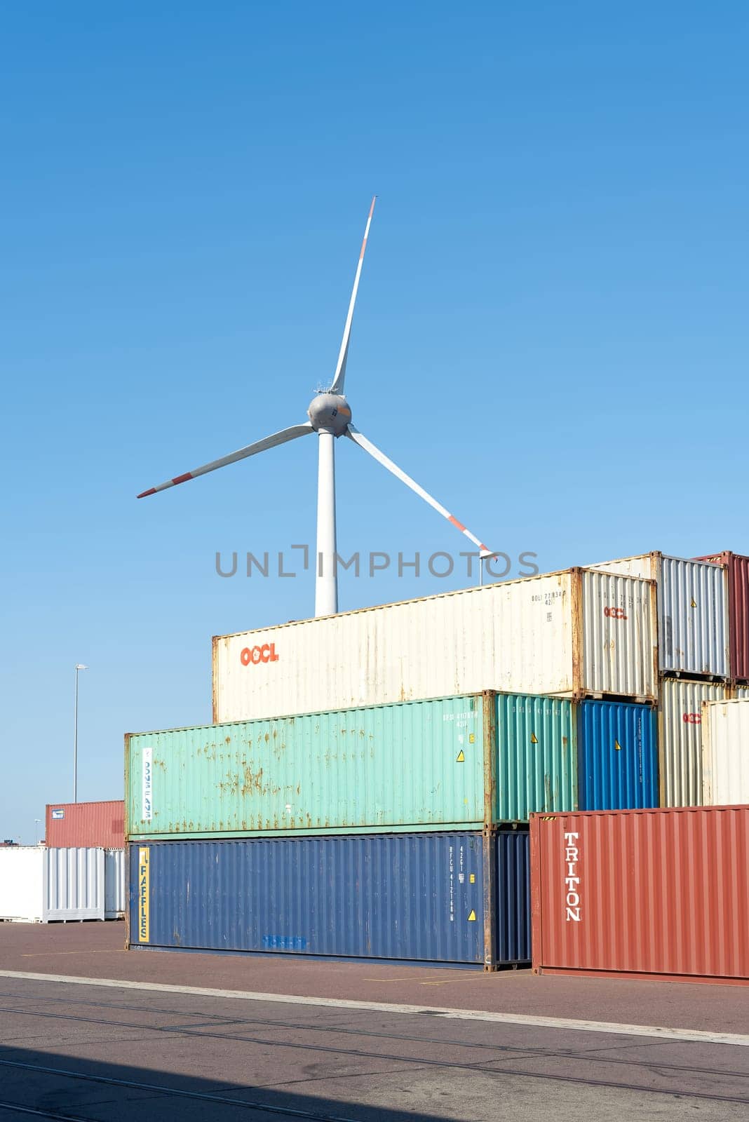 Containers from all over the world in the port of Magdeburg. In the background, a wind turbine.