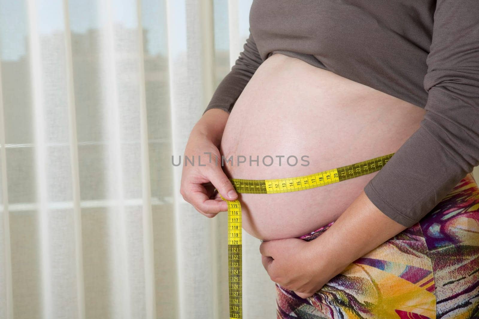 Closeup of pregnant woman at home