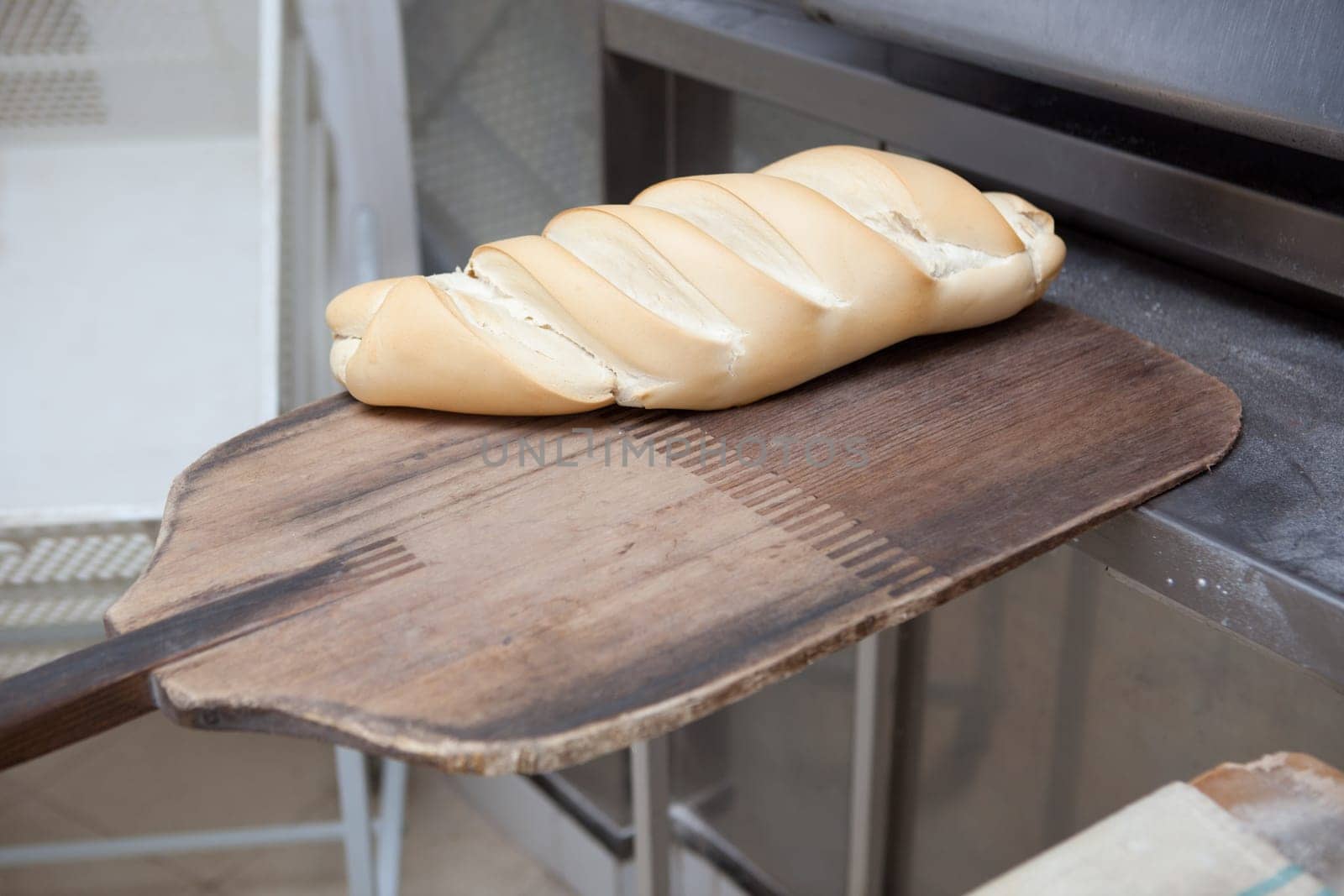 baking peel taking fresh baked bread from oven. Manufacturing process of spanish bread