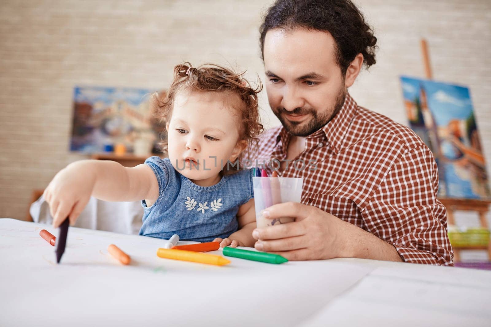 Handsome man and his small daughter drawing