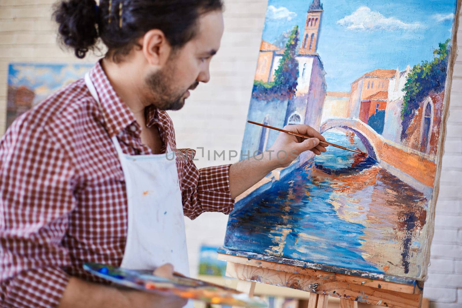 Young artist painting Italian landmark in studio