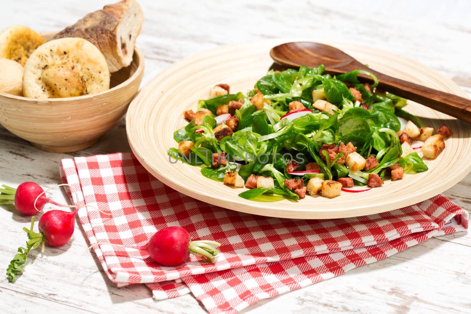 Field salad with bacon cubes,croutons and radishes,studio