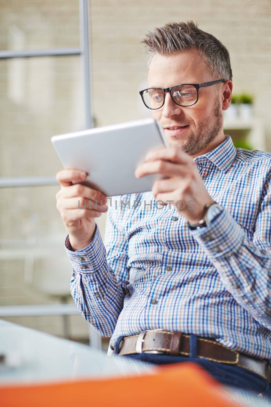 Restful businessman with touchpad sitting in office