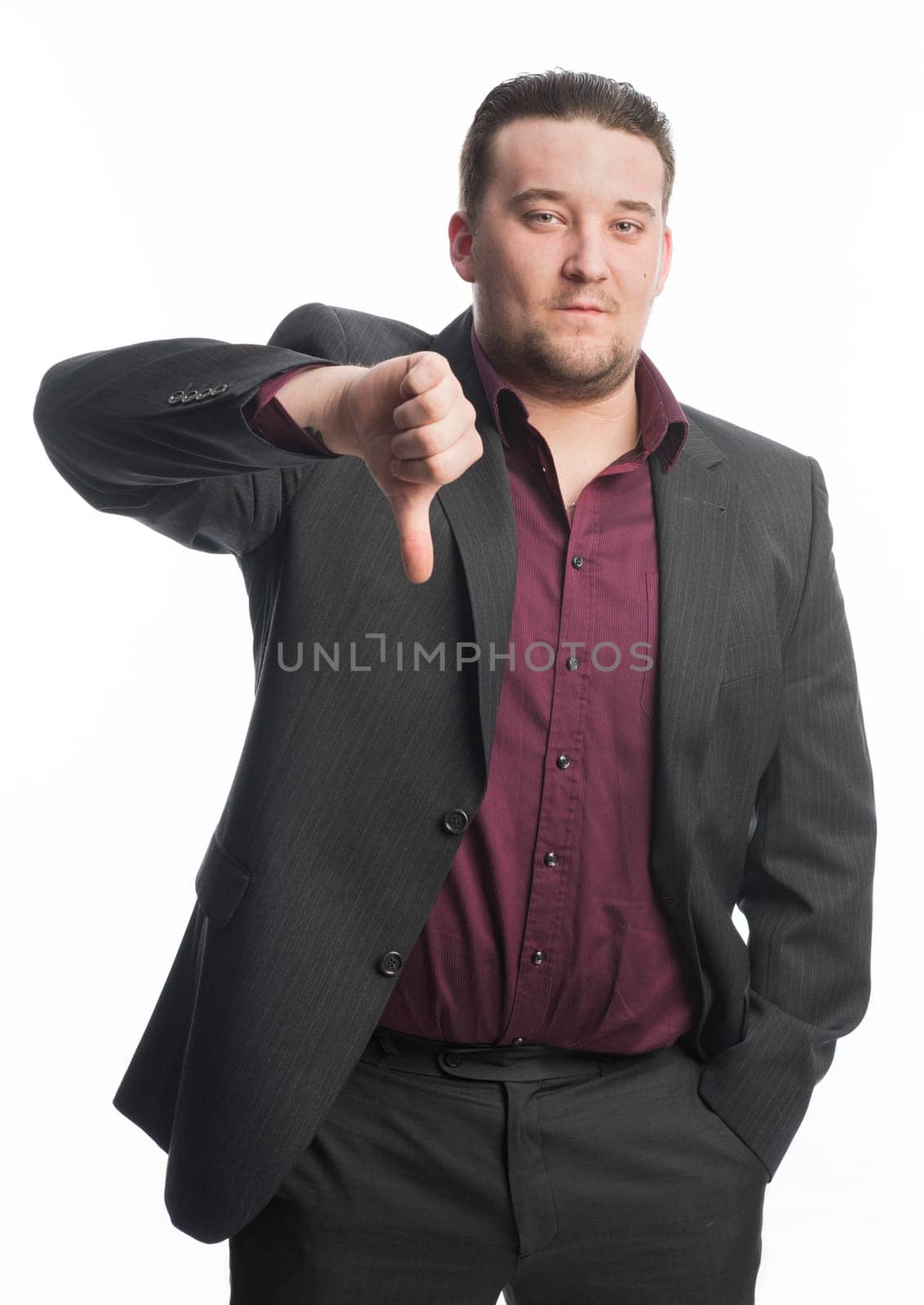 Young man in suit shows off thumbs down