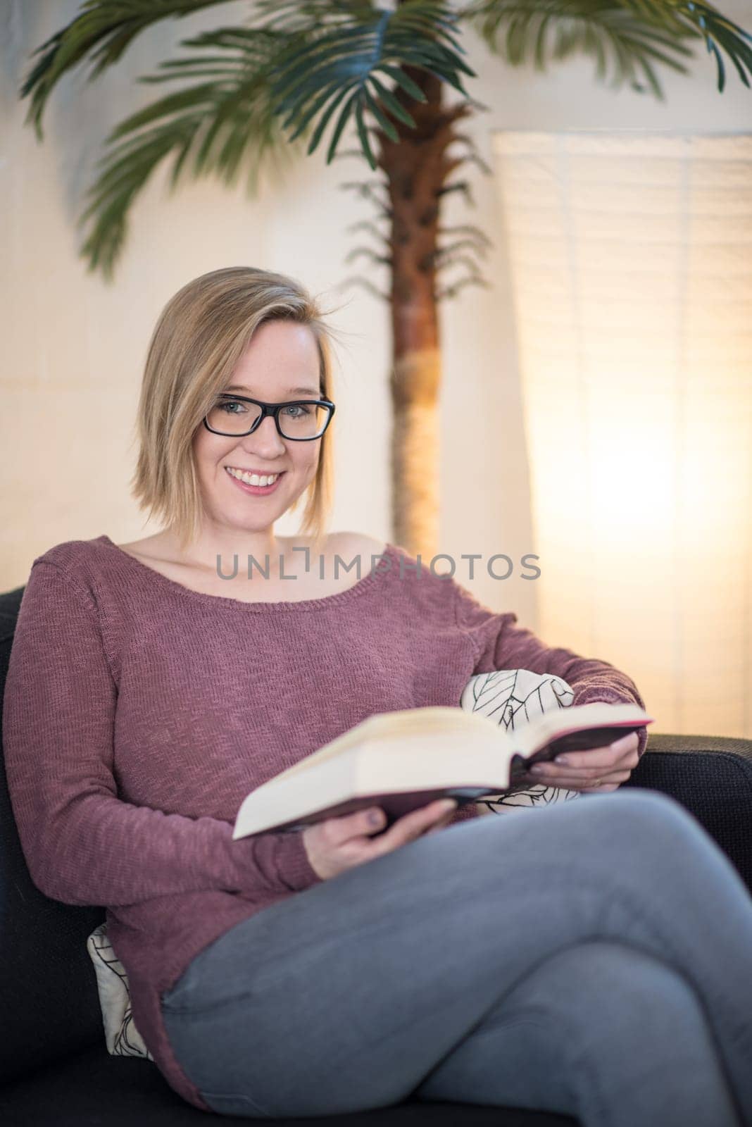 Young woman with glasses reads a book