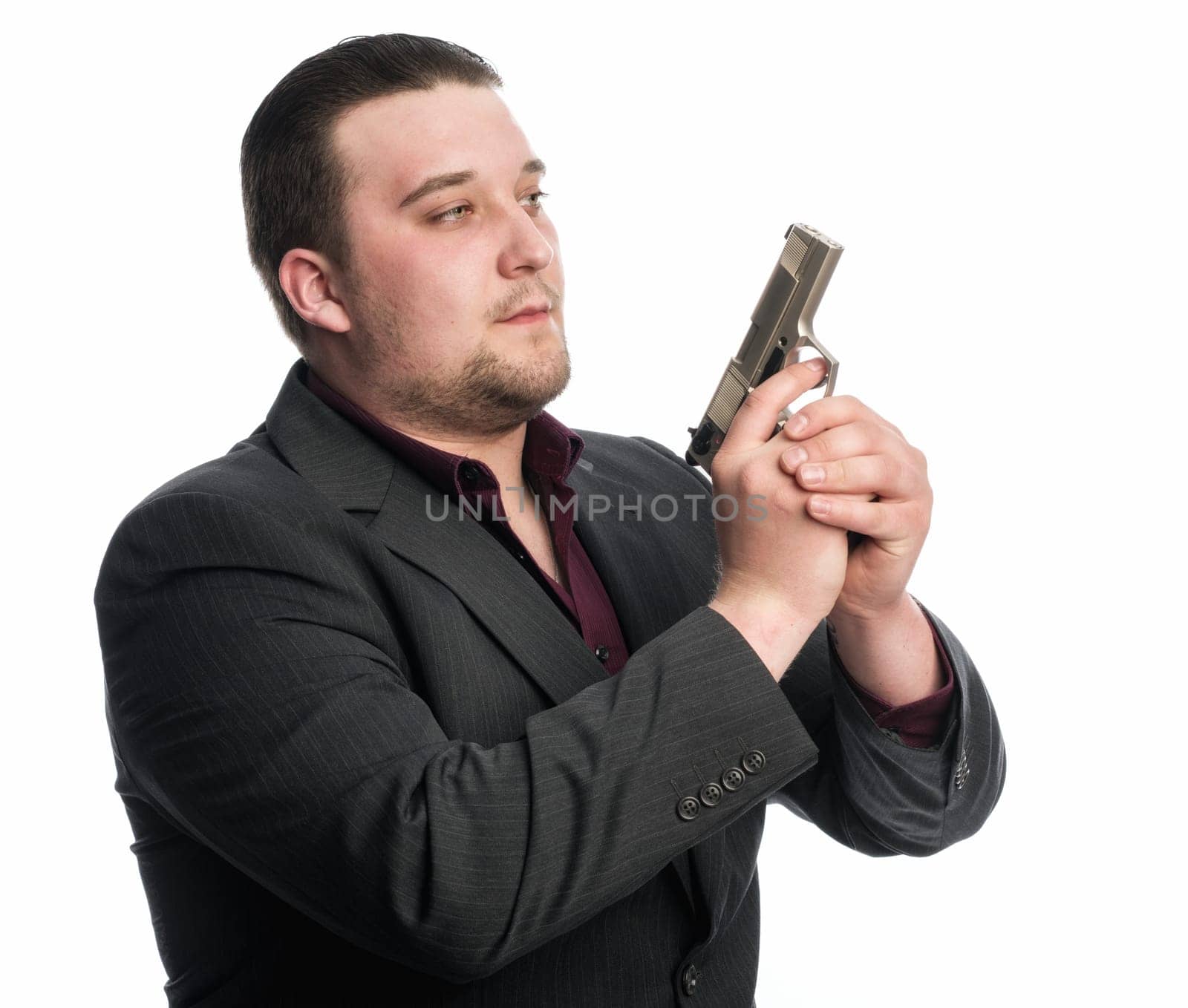 Young man in suit carries a gun