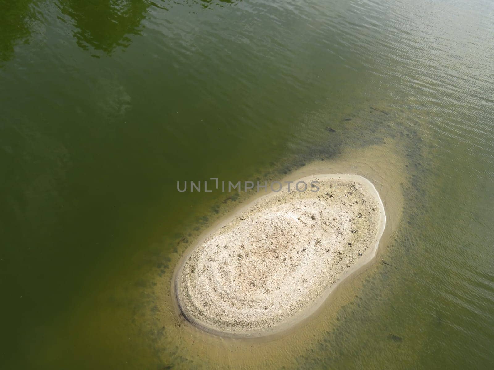 small island in a river surrounded by water and composed of sand