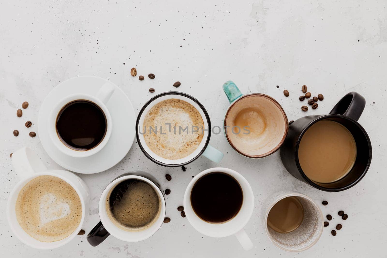 Top view on flat lay with many different full and empty coffee cups composition on gray white concrete background. Variety of tea mug collection layout. Dried coffee beans. Espresso, latte, americano