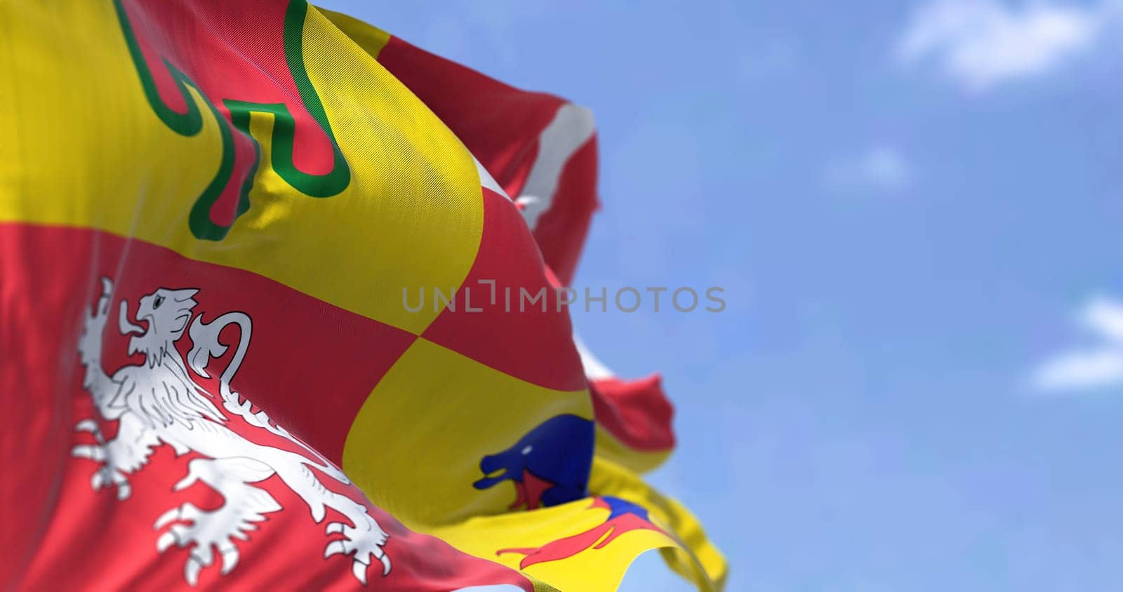 The flag of Auvergne-Rhone-Alps flying on a clear day. Auvergne-Rhone-Alpes is one of the regions of France.