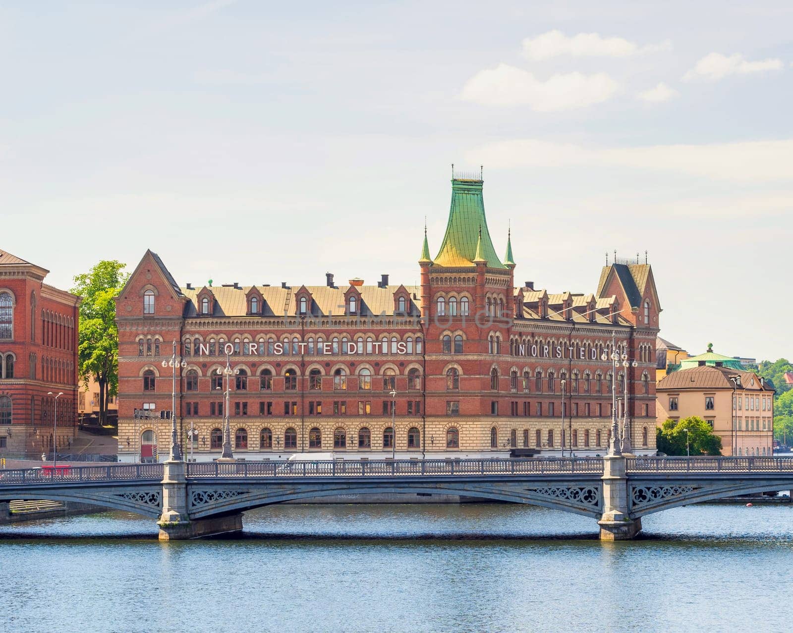 Norstedt Building, or Norstedtshuset, overlooking The Vasa Bridge, or Vasabron, located in central Stockholm, in a summer sunny day. The bridge connects Norrmalm to Gamla stan, Stockholm, Sweden