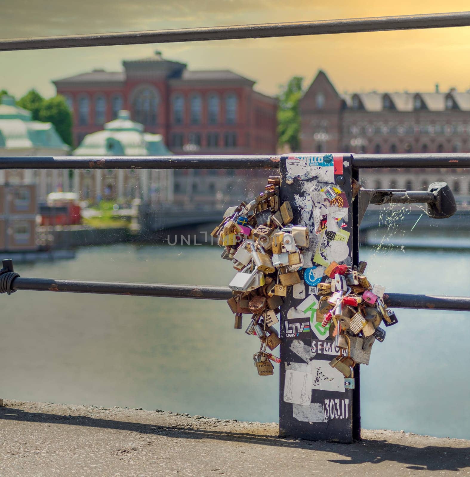 Stockholm, Sweden - June 26 2022: Love locks attached by lovers to the railing of Riksbron Bridge, or The National Bridge, Gamla Stan