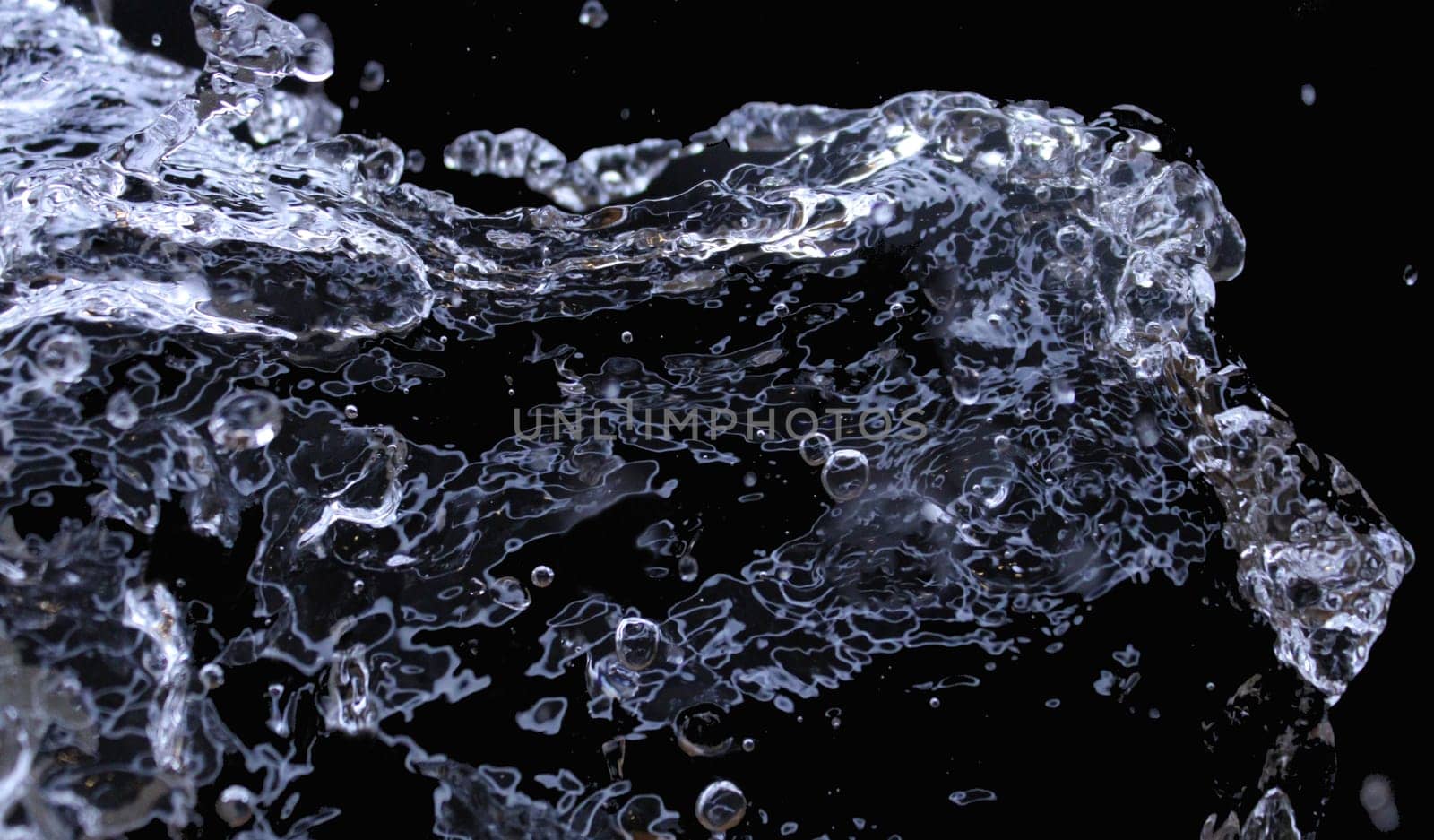 Isolated splashes of water on a black background. Abstract background. Ecological concept..