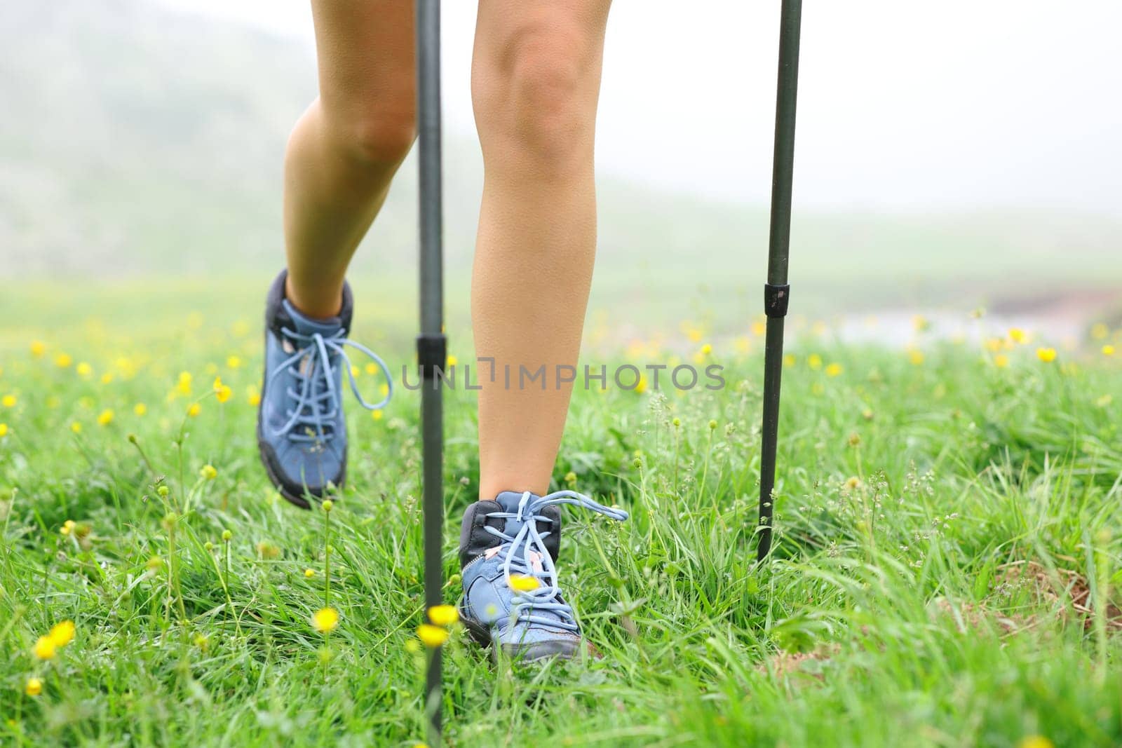 Close up of a hiker legs walking on the grass a foggy day in the mountain