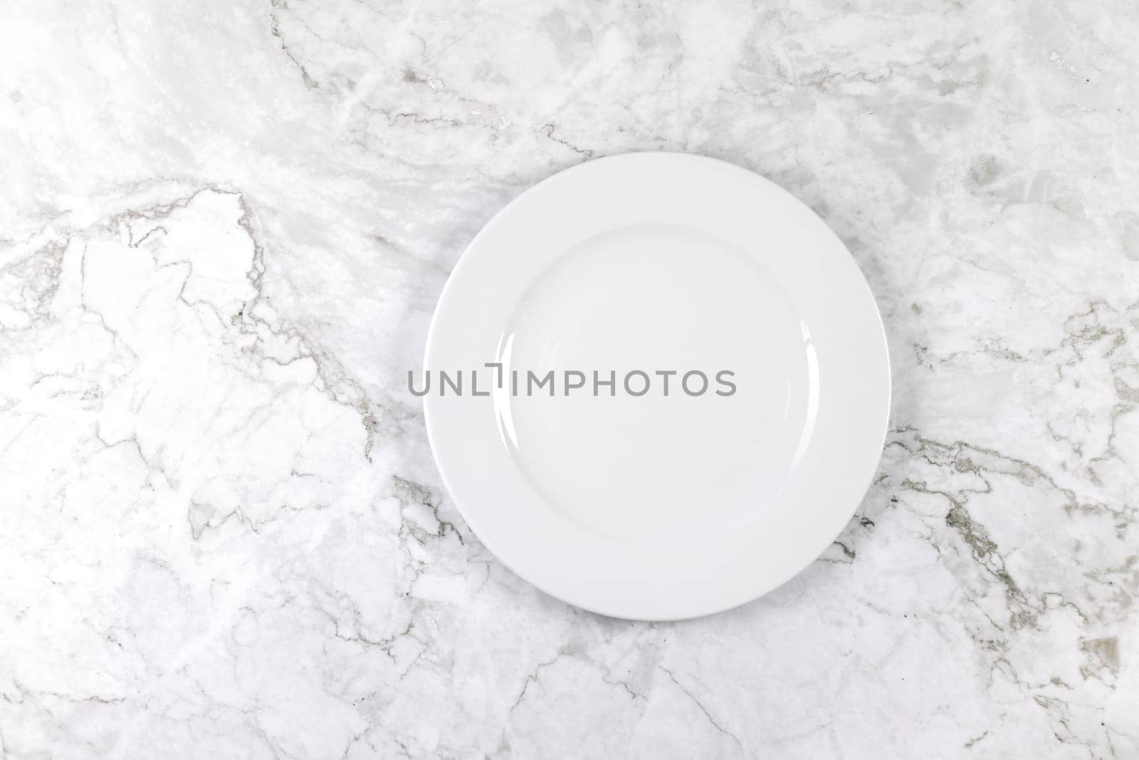 A dinner plate on a white and grey marble surface