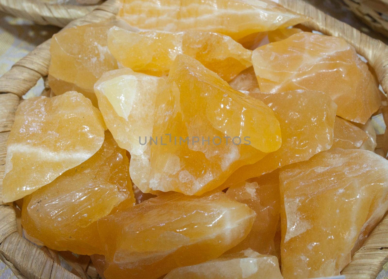 Yellow calcite fragments, believed to have beneficial health properties. Displayed on basket at street market stall