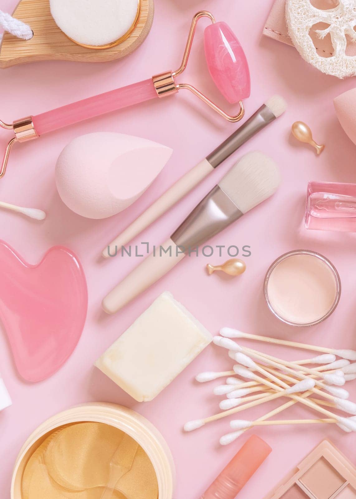 Skin care and makeup products on light pink, top view. Flat lay with natural beauty products and decorative cosmetics. Everyday woman face care routine. Pastel composition