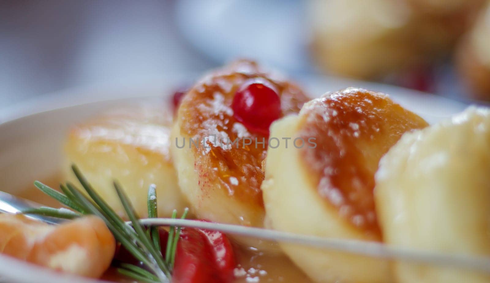 Close up fresh serving of four round paneer cheesecakes in salted caramel on a plate on the restaurant table in eco style. Cheesecakes or cottage cheese pancakes in a ceramic bowl. Morning breakfast