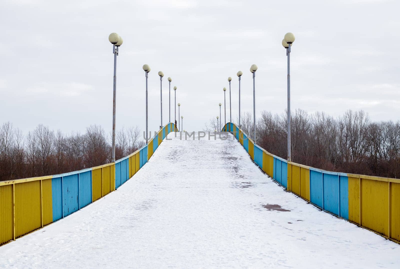 Pedestrian bridge in Chernihiv across the Desna river in the snow on a winter snowy day