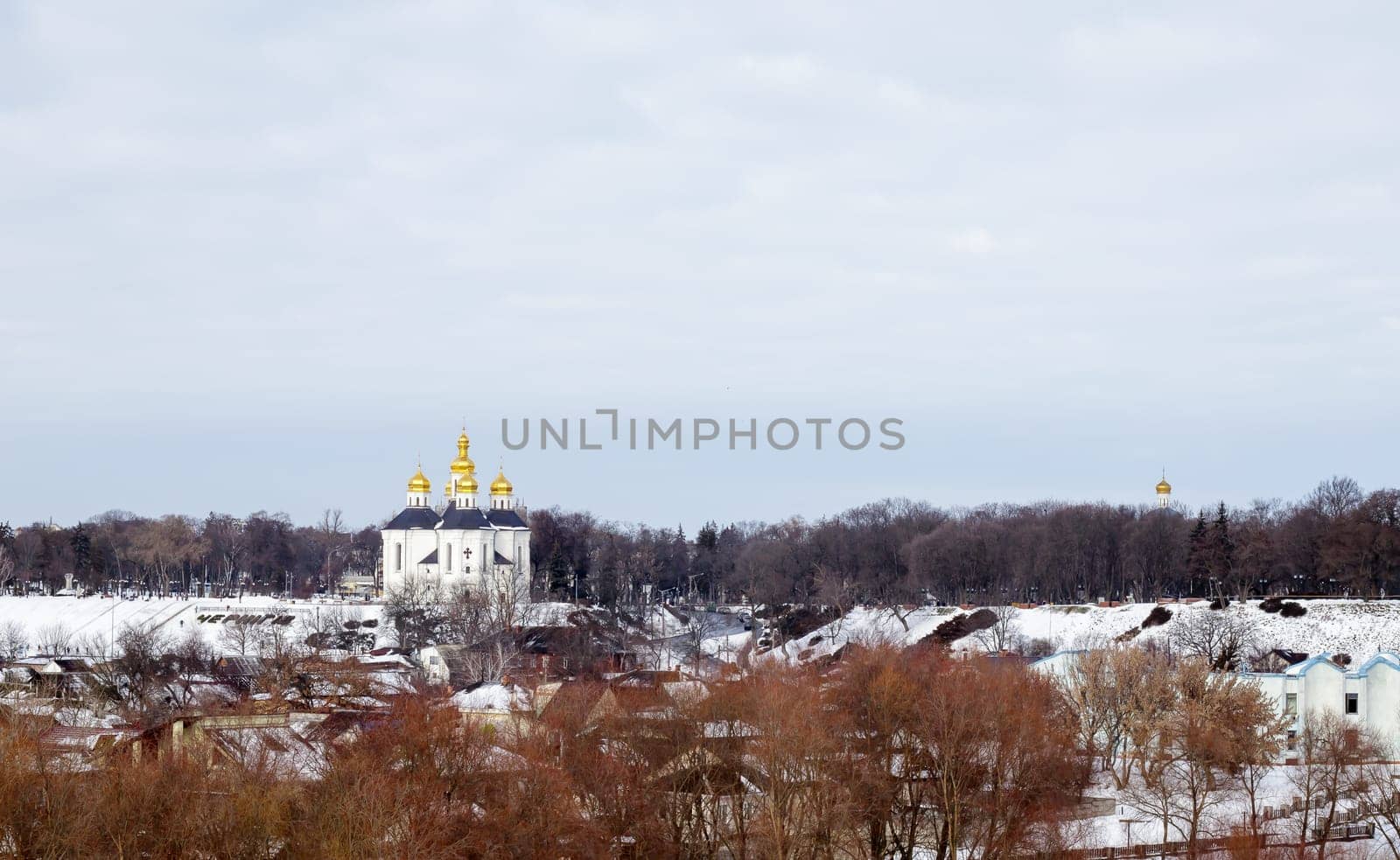 Orthodox Church of St. Catherine in the Ukrainian city of Chernihiv and a view of the city in winter with snow. Old beautiful temple in the city