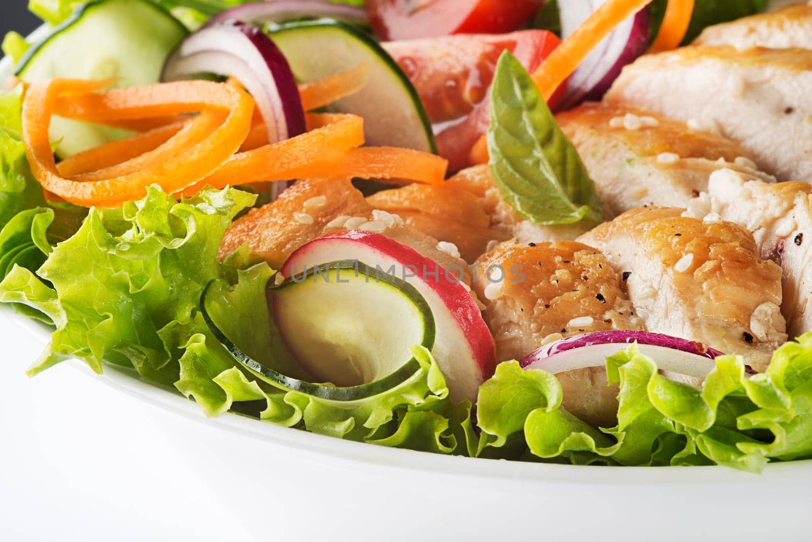 Healthy green salad with chicken breast and fresh vegetables close up