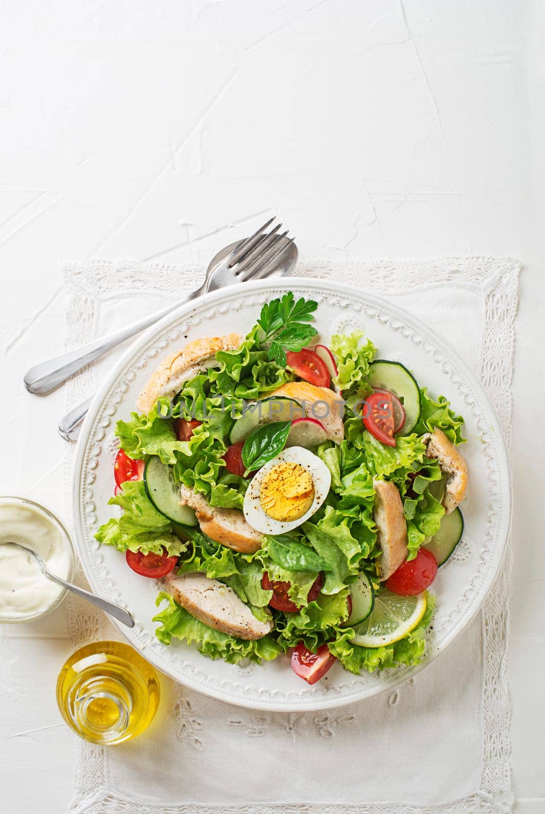 Fresh green salad with chicken breast vegetable and boiled egg on white background