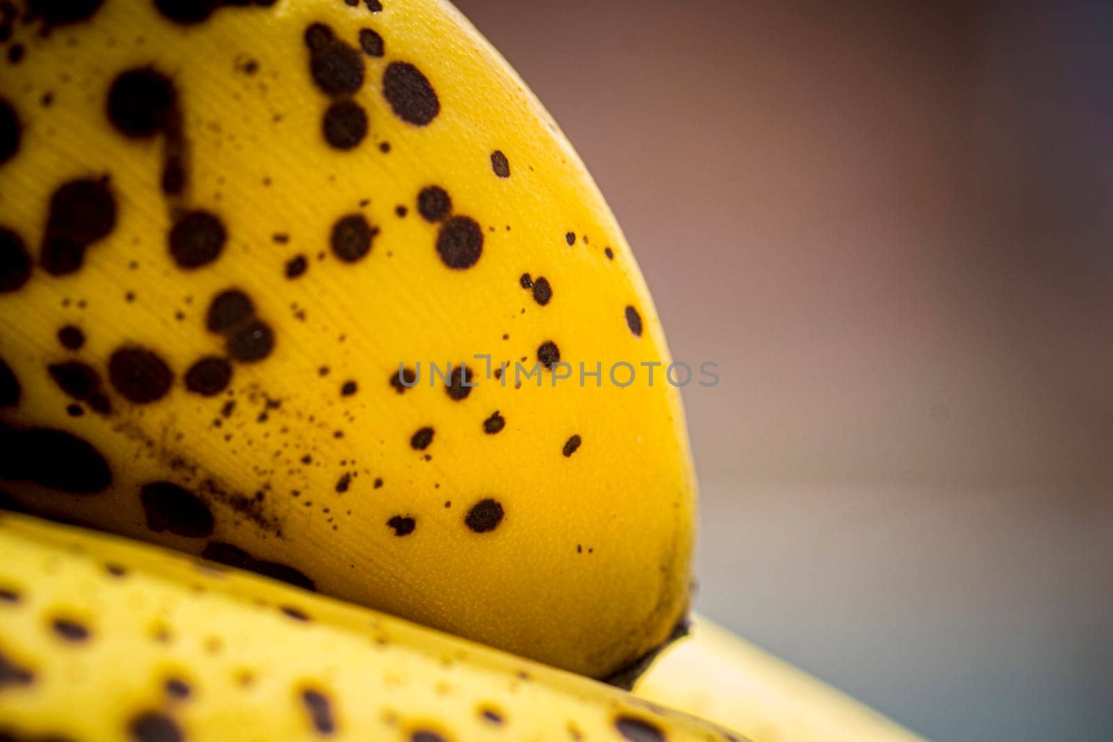 Closeup of banana ripening stage with spots, sweet flavor, perfect for blender drinks an baking