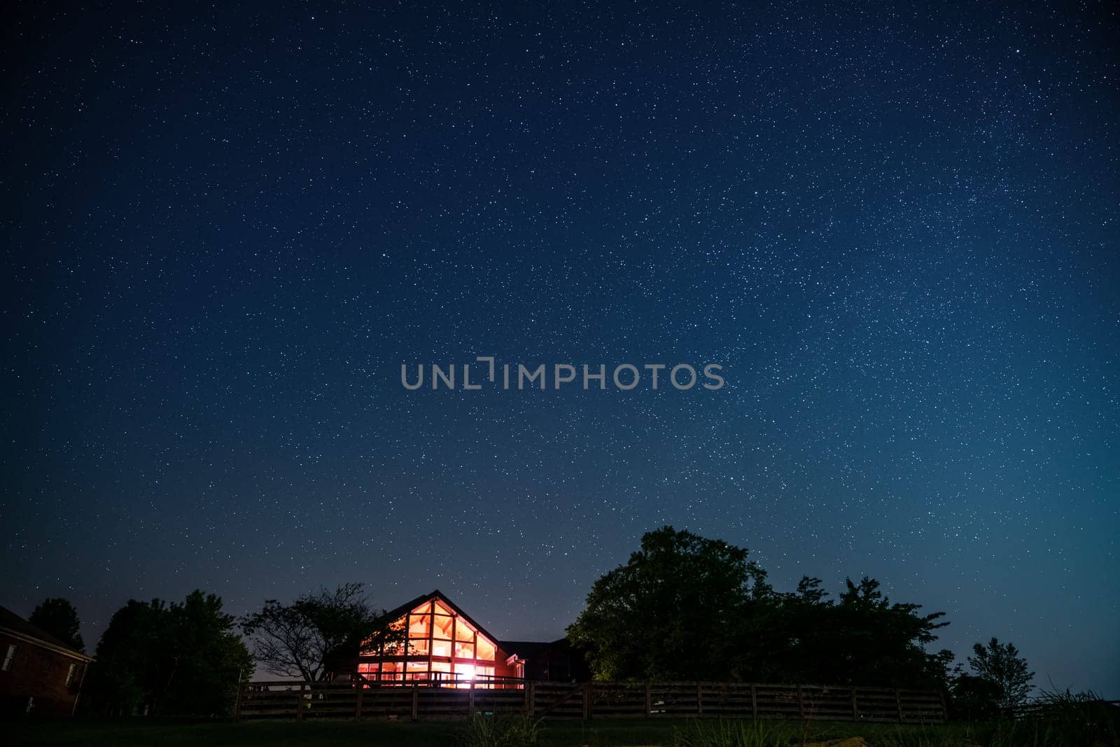 View of night sky and the Milky Way with a house in rural Kentucky in the foreground