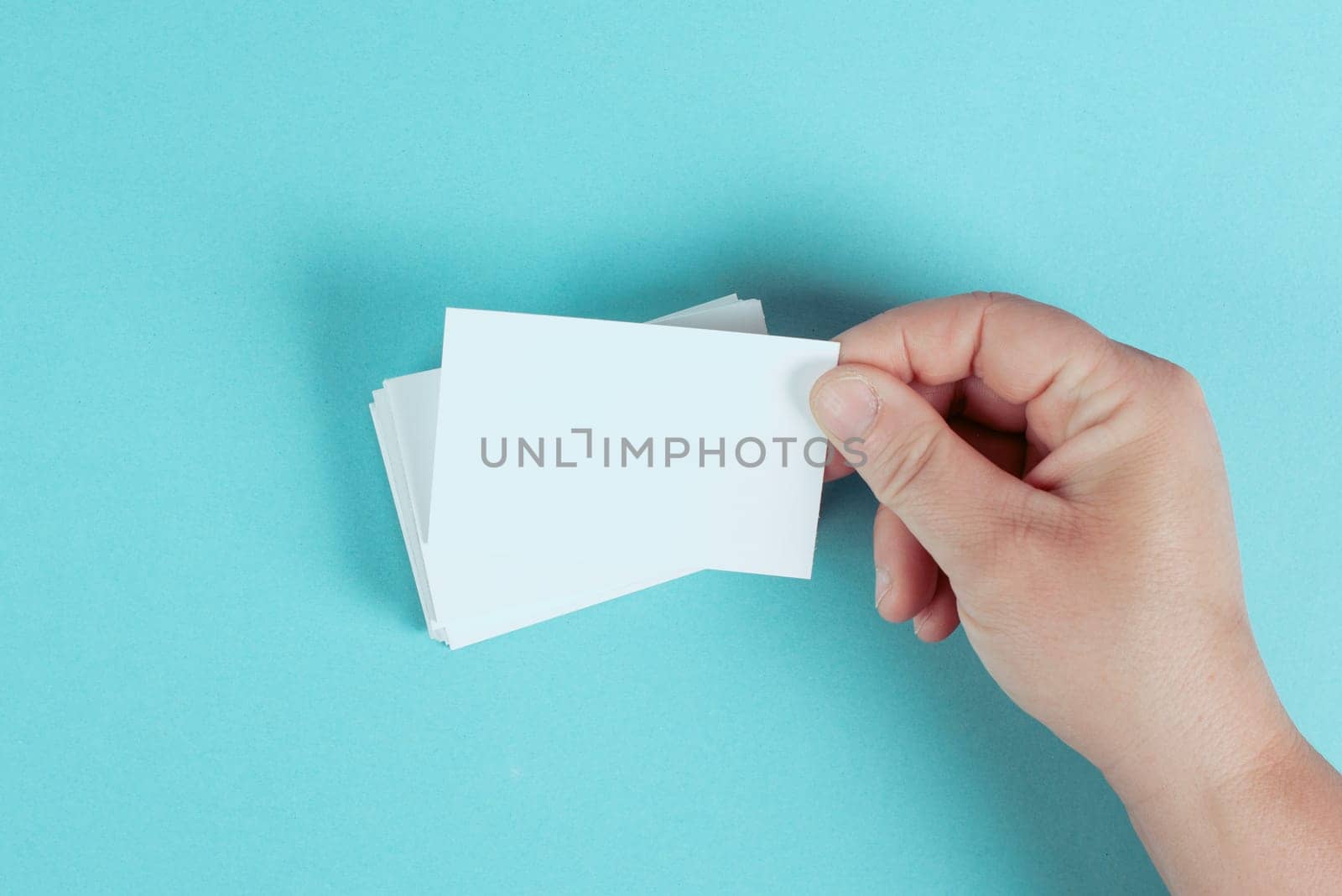 Holding a blank business card in the hand, copy space for text, marketing and advertising concept