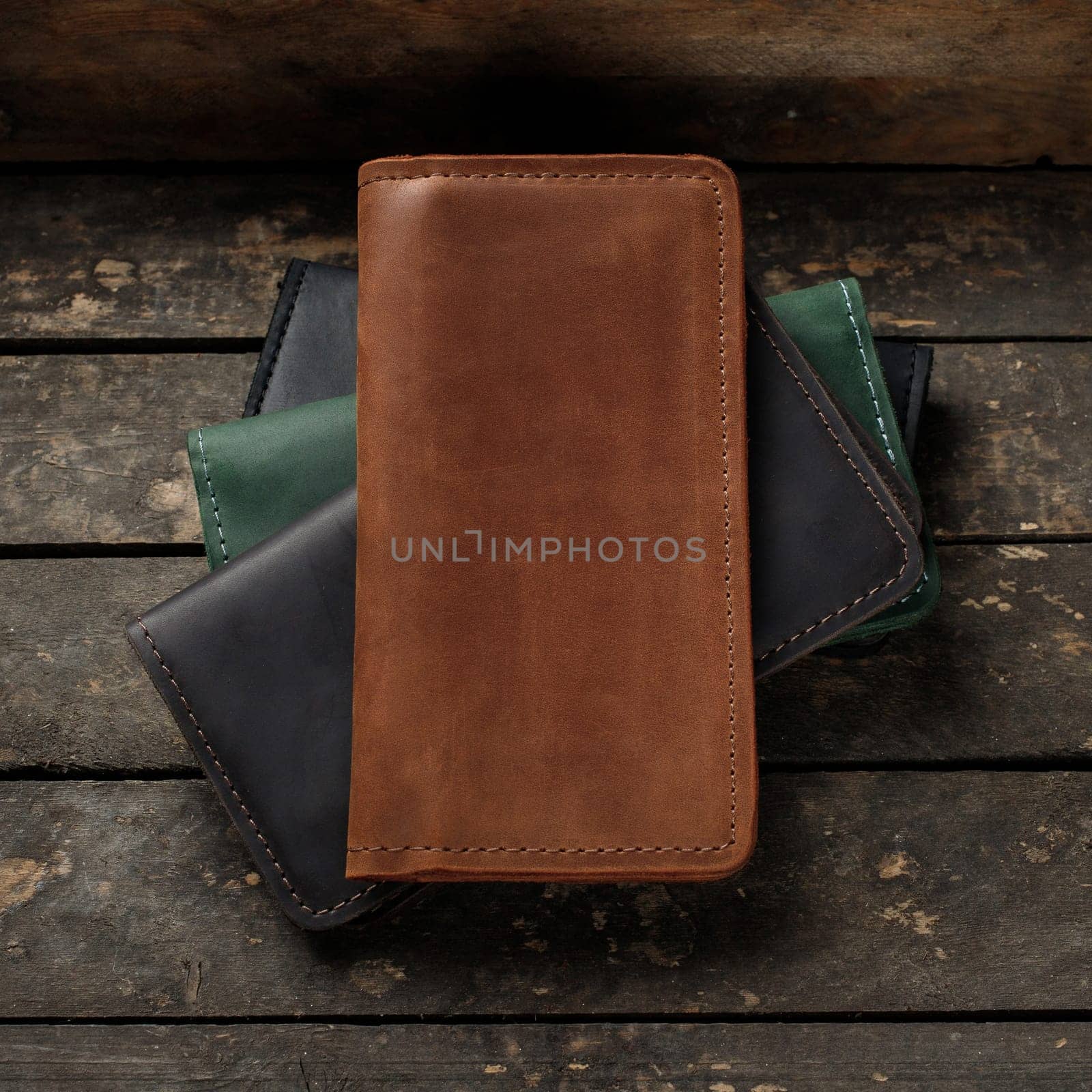 Set of stylish leather wallets on a vintage wooden background. Red, black, brown, green. Place for text