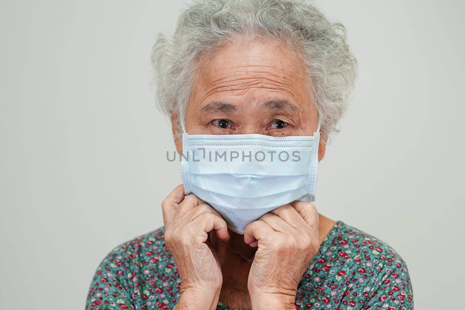 Asian elderly woman patient wearing a mask for protect Covid-19 Coronavirus.
