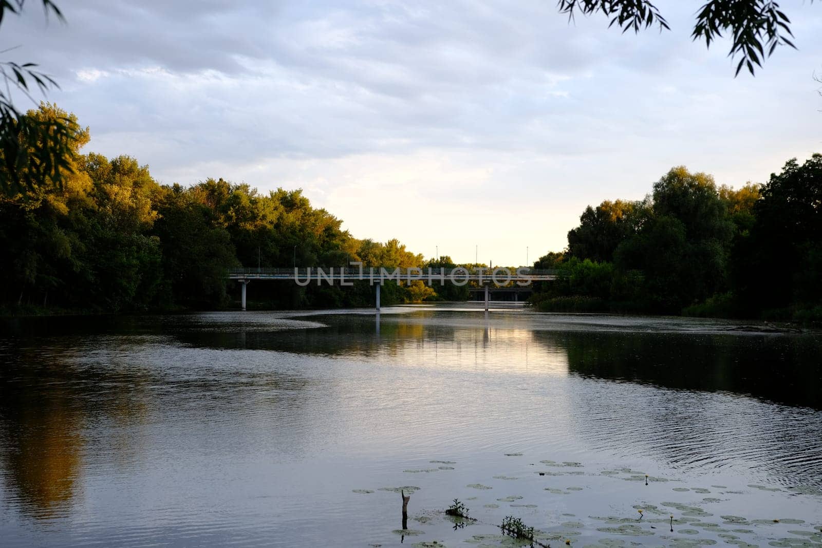 Panoramic View of Old blue Bridge across Still Waters of River.