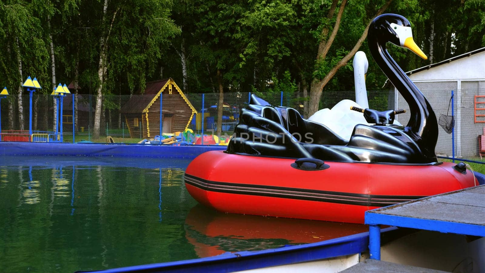 view of inflatable boats in the form of birds swan, pelican on the water in the pool in the spring.
