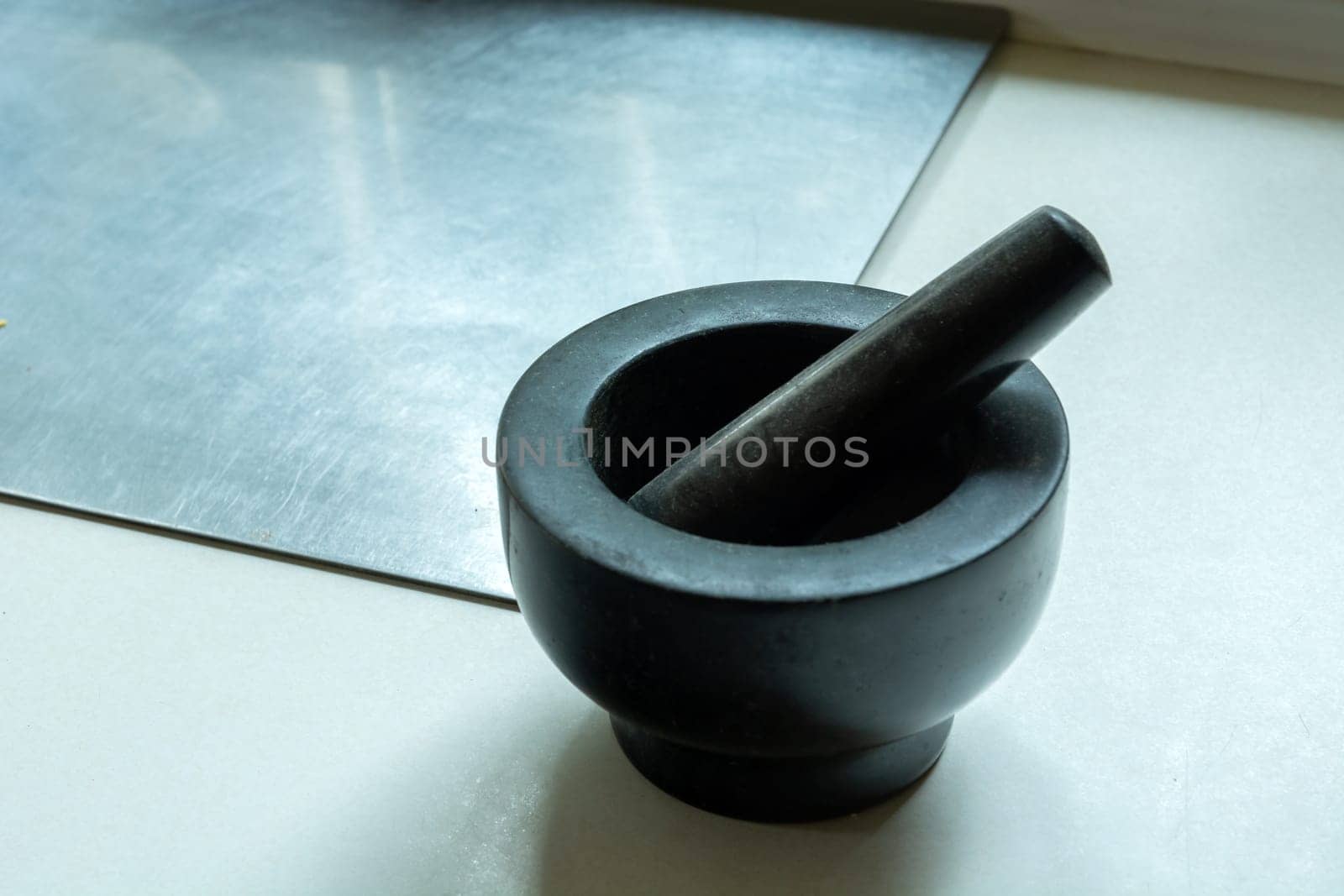 Dark stone kitchen mortar on the countertop, close up