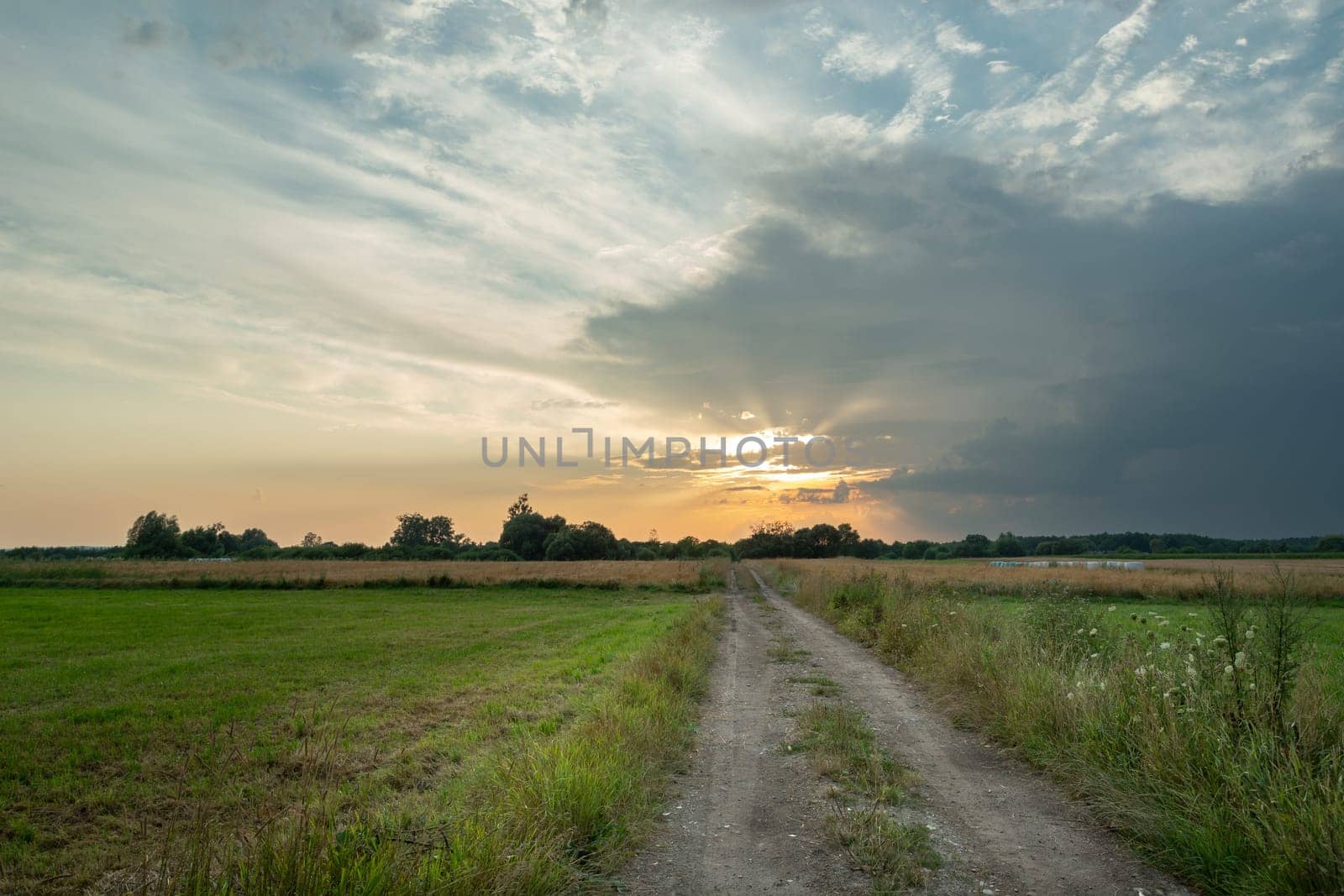 Rural road through fields and clouds during sunset, Nowiny, Poland