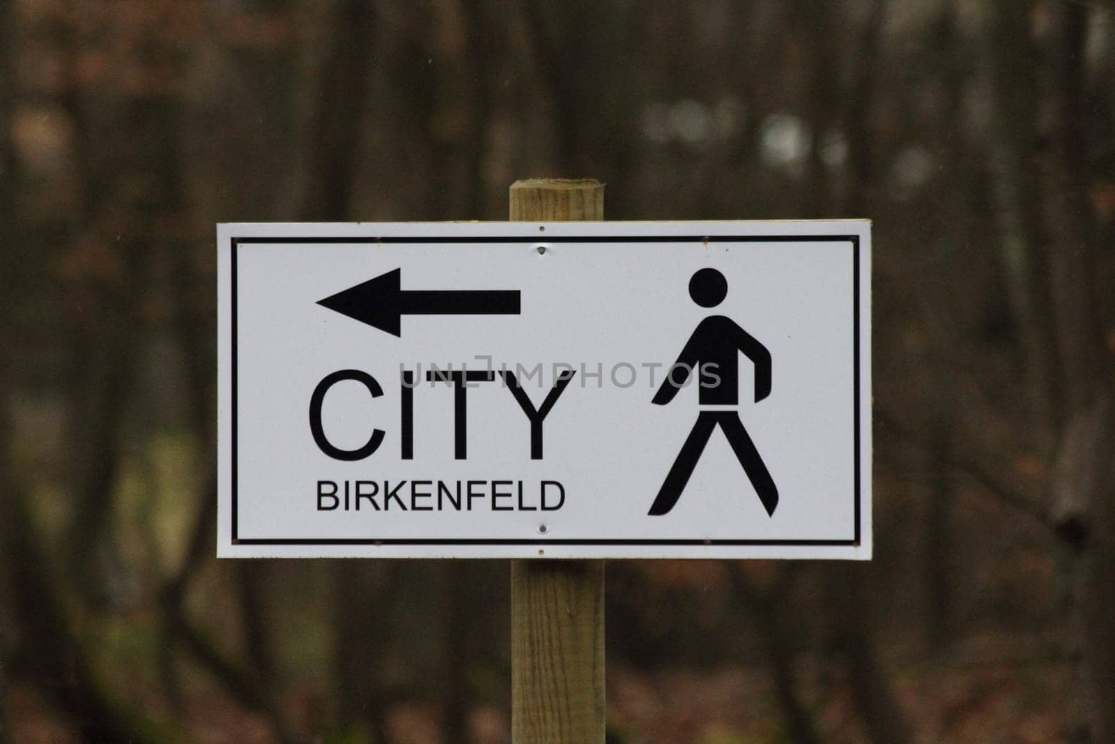 A signboard with inscription, arrow and symbol.Ein Hinweisschild mit Aufschrift, Pfeil und Symbol.