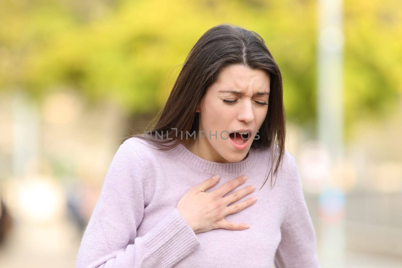 Stressed teen having breath problems standing in a park