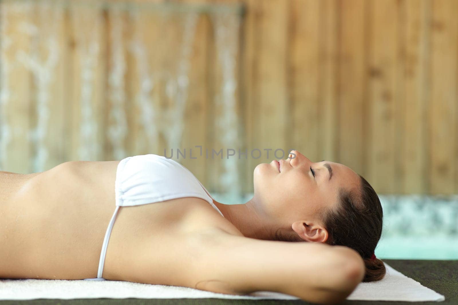 Side view portrait of a woman relaxing lying in the floor of spa