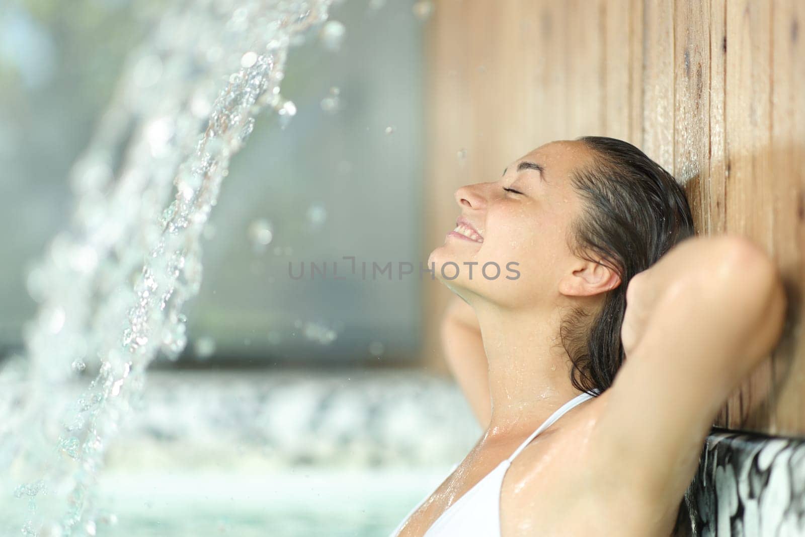 Side view porrtrait of a happy woman resting bathing in spa