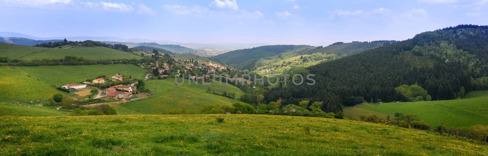 Typical village in the french countryside by spring with green grass and natural hills