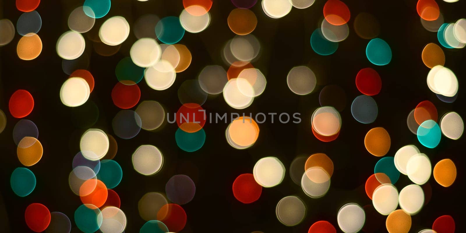 Festive background. A dark table and blurry multicolored lights in the background.