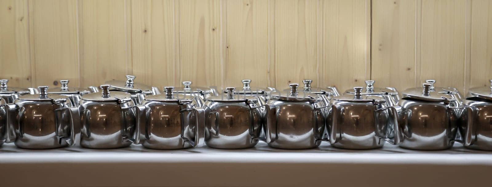Many coffee pots stand side by side in one compartment.