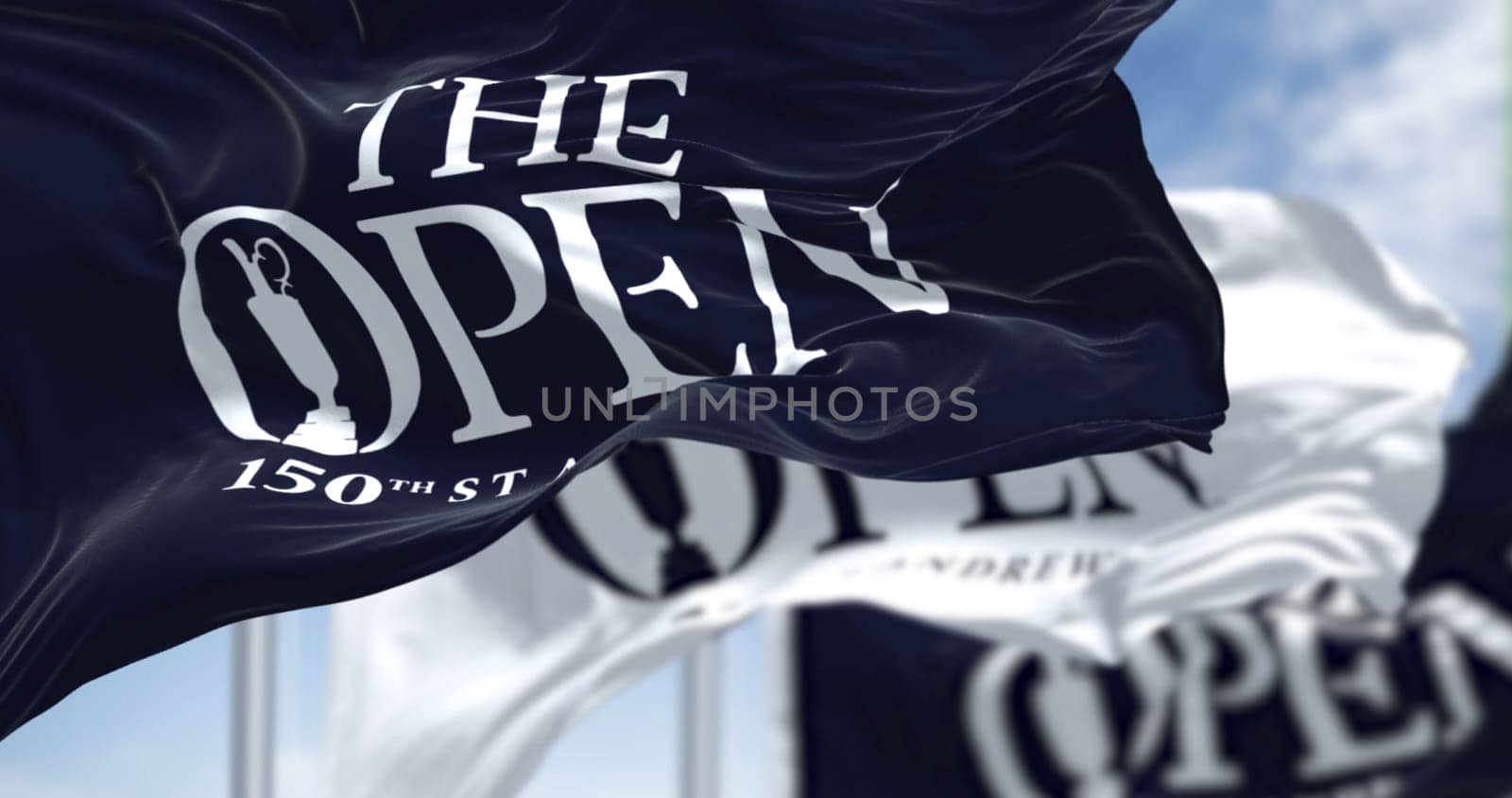 St Andrews, Scotland, June 2022: Three flags with the logo of the 150th The Open Golf Championship are waving in the wind. The Open is a golf tournament to be played 14–17 July in St Andrews, Scotland