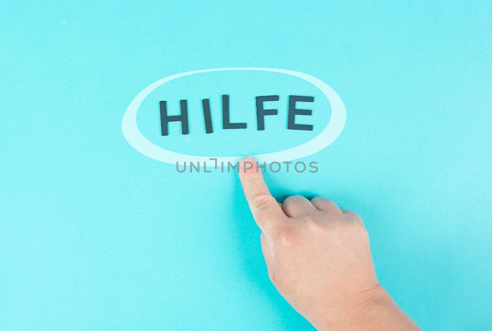 Pointing to the word help with the finger, german language, giving support and charity